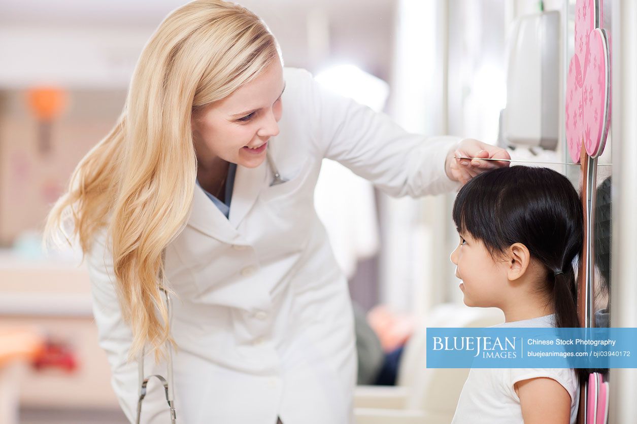 Chinese doctor measuring girl's height