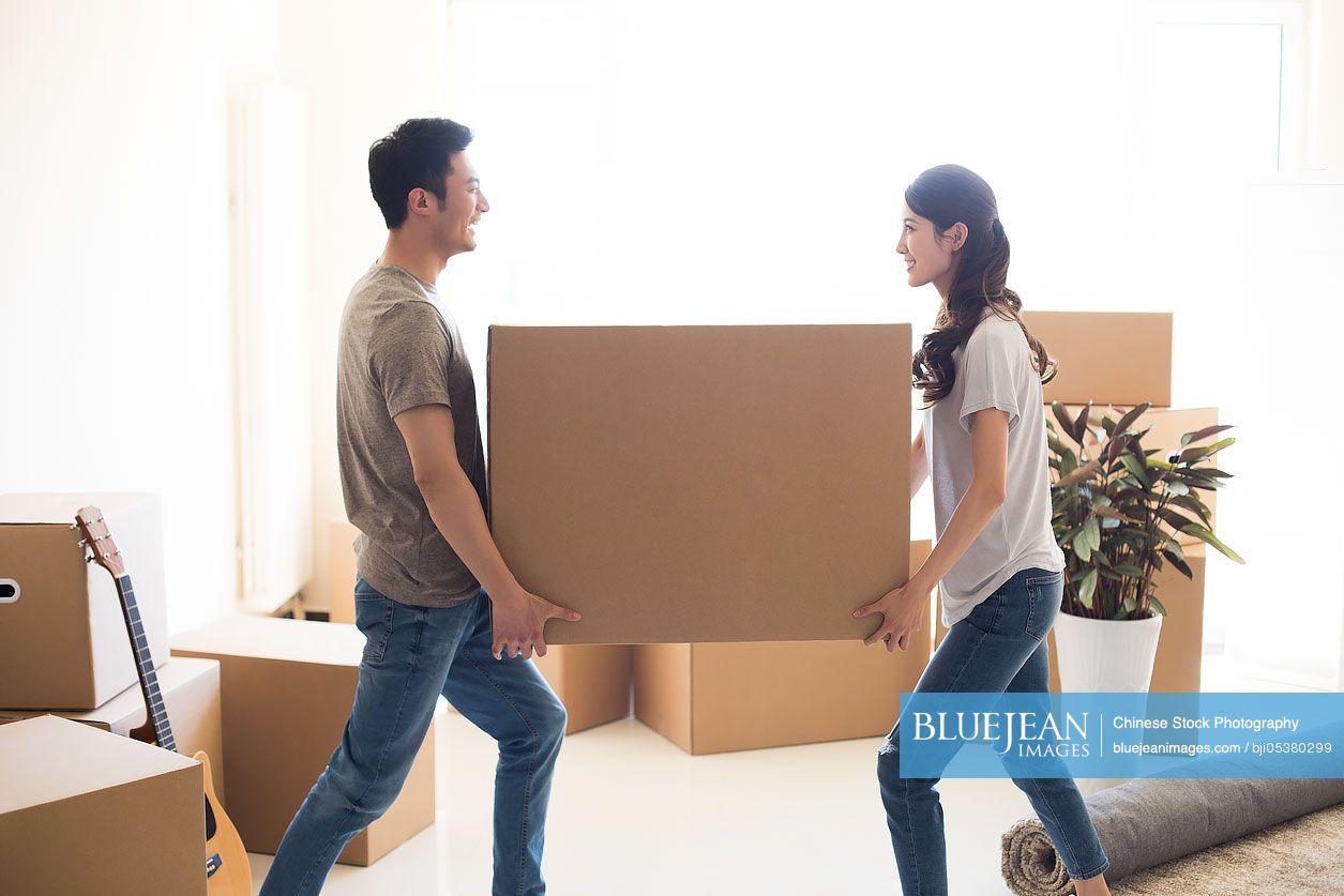 happy-young-chinese-couple-moving-to-a-new-house-high-res-stock-photo