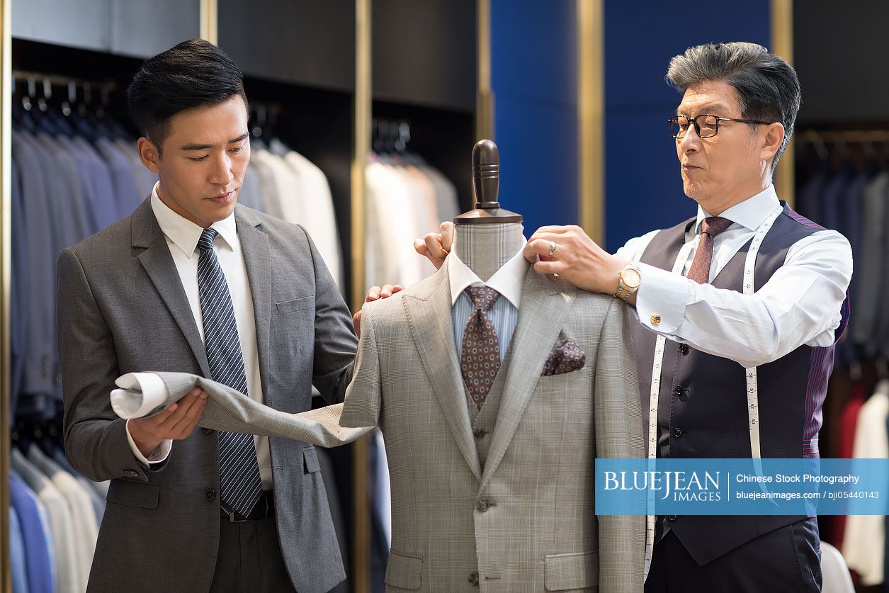 Chinese fashion designer showing customer business suit