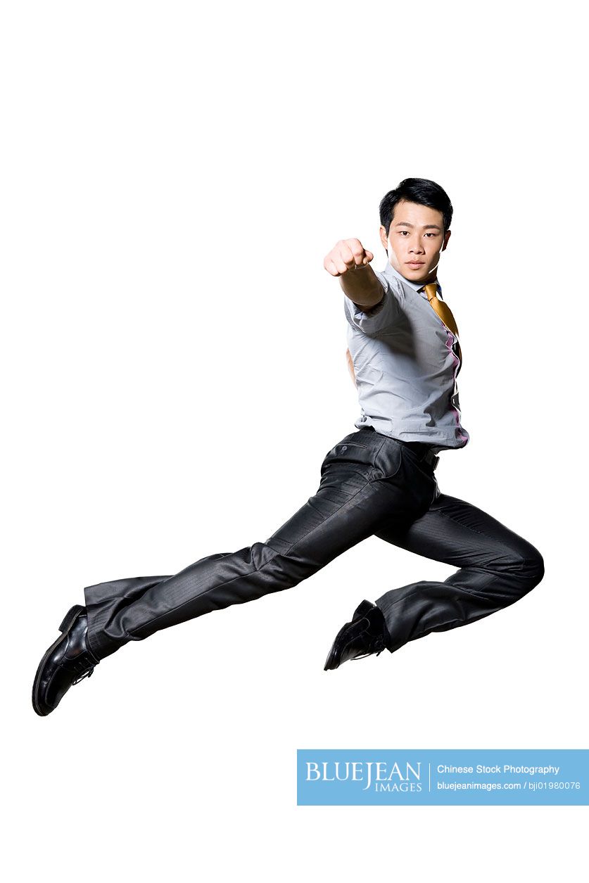 Chinese businessman doing martial arts punch in mid air