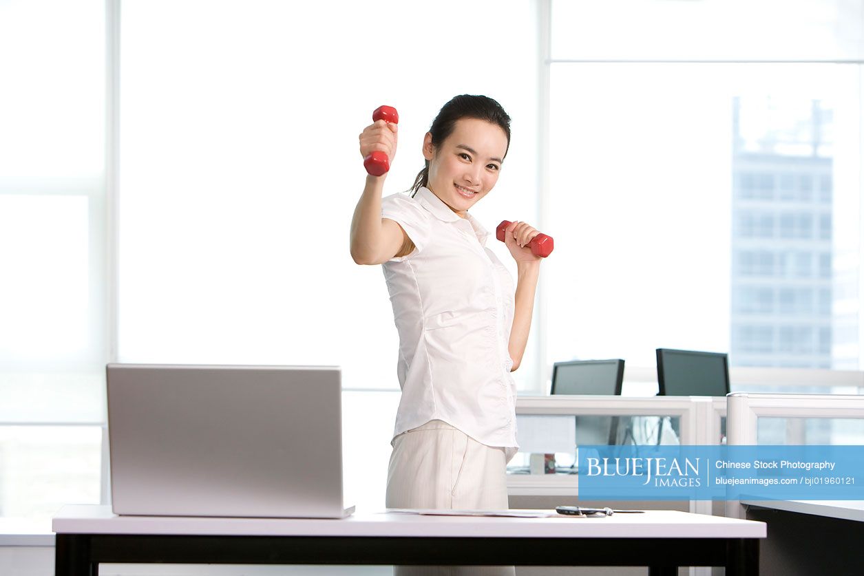 Chinese office worker working out in the office