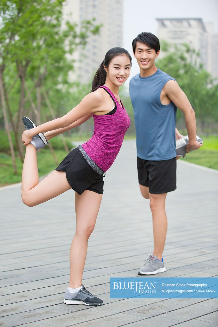 Young Chinese couple stretching outside