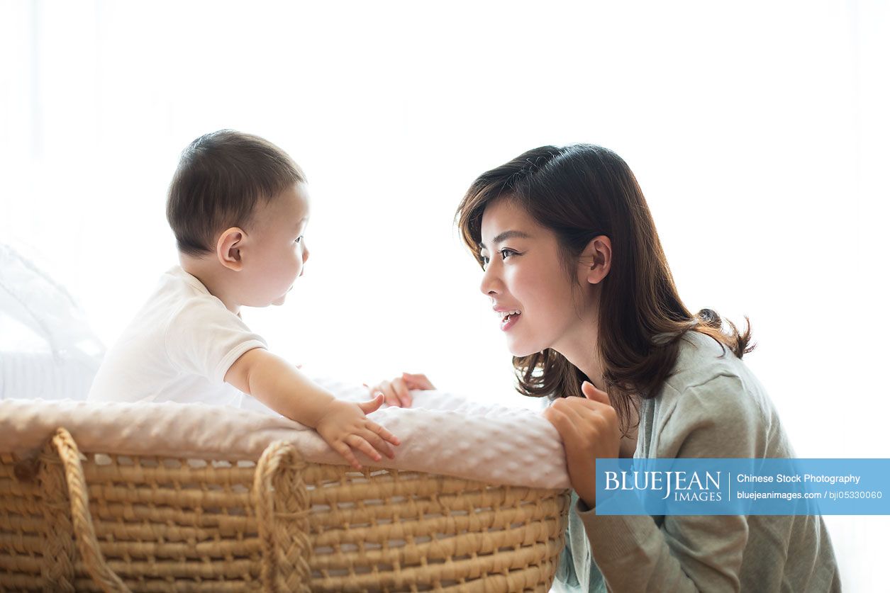 Happy Chinese mother and cute baby at home