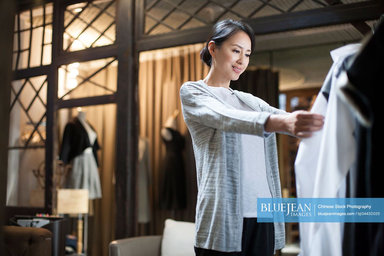 Chinese clothing store owner checking clothes