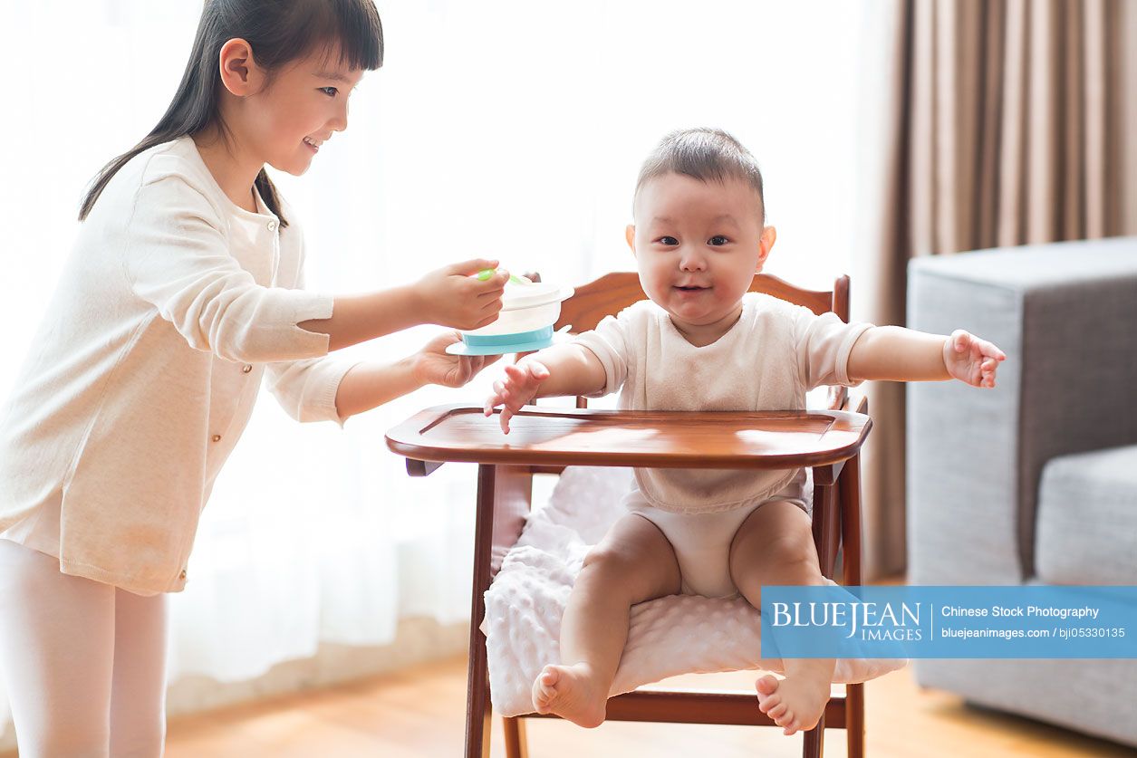 Little Chinese girl feeding baby