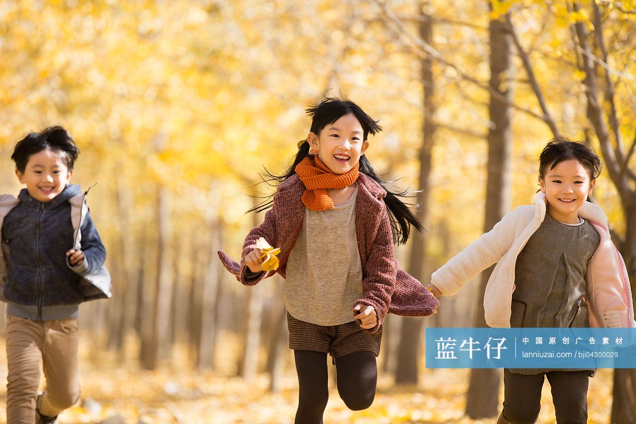 三个小孩在秋日的树林里奔跑