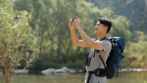 Young Chinese man hiking outdoors