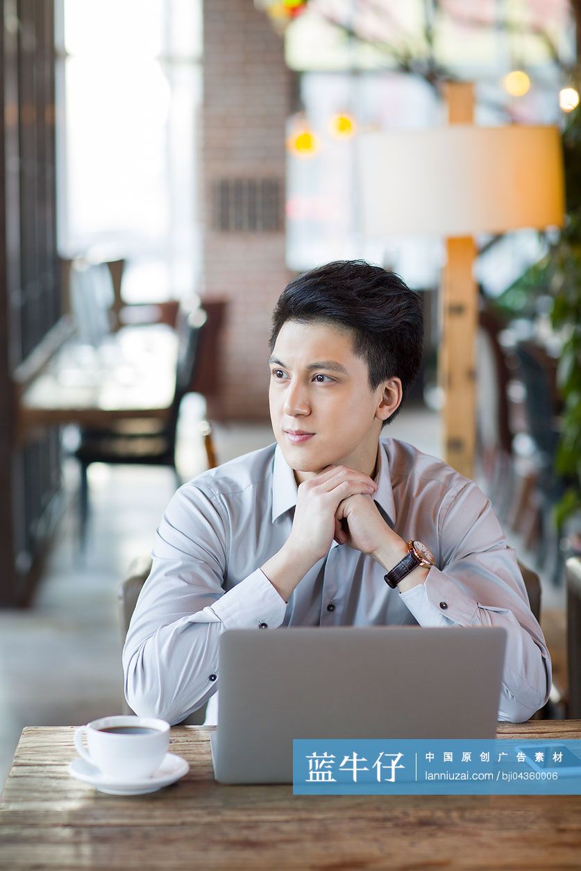 年轻男子在咖啡馆使用笔记本电脑
