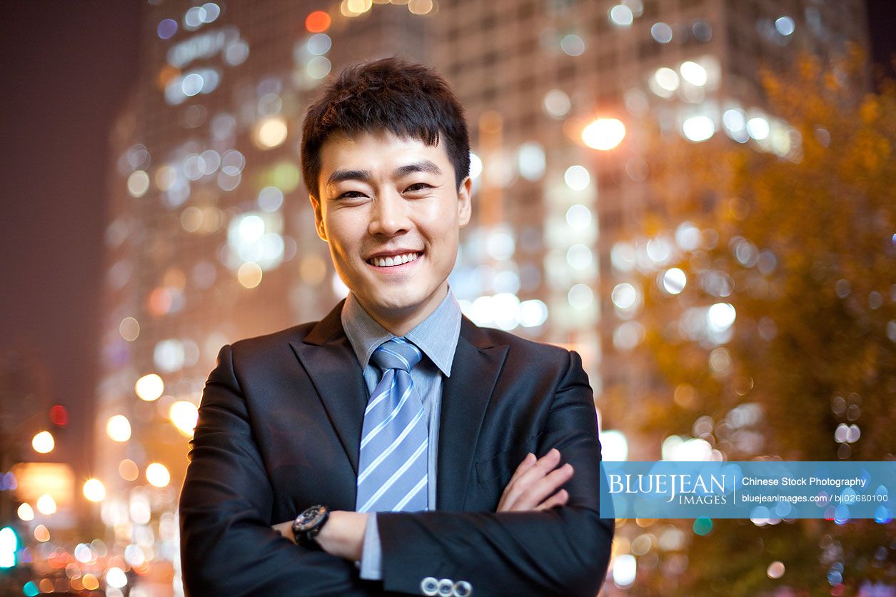 Chinese businessman with city lights in the background