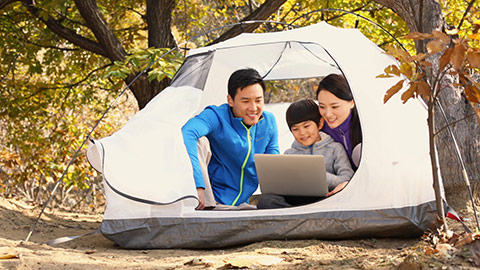 Happy young Chinese family using laptop in tent,HD