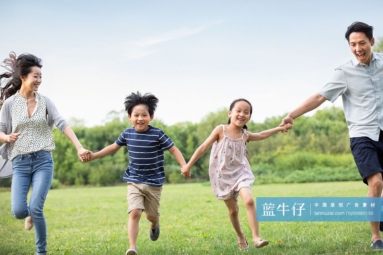 快乐年轻家庭在草地上奔跑