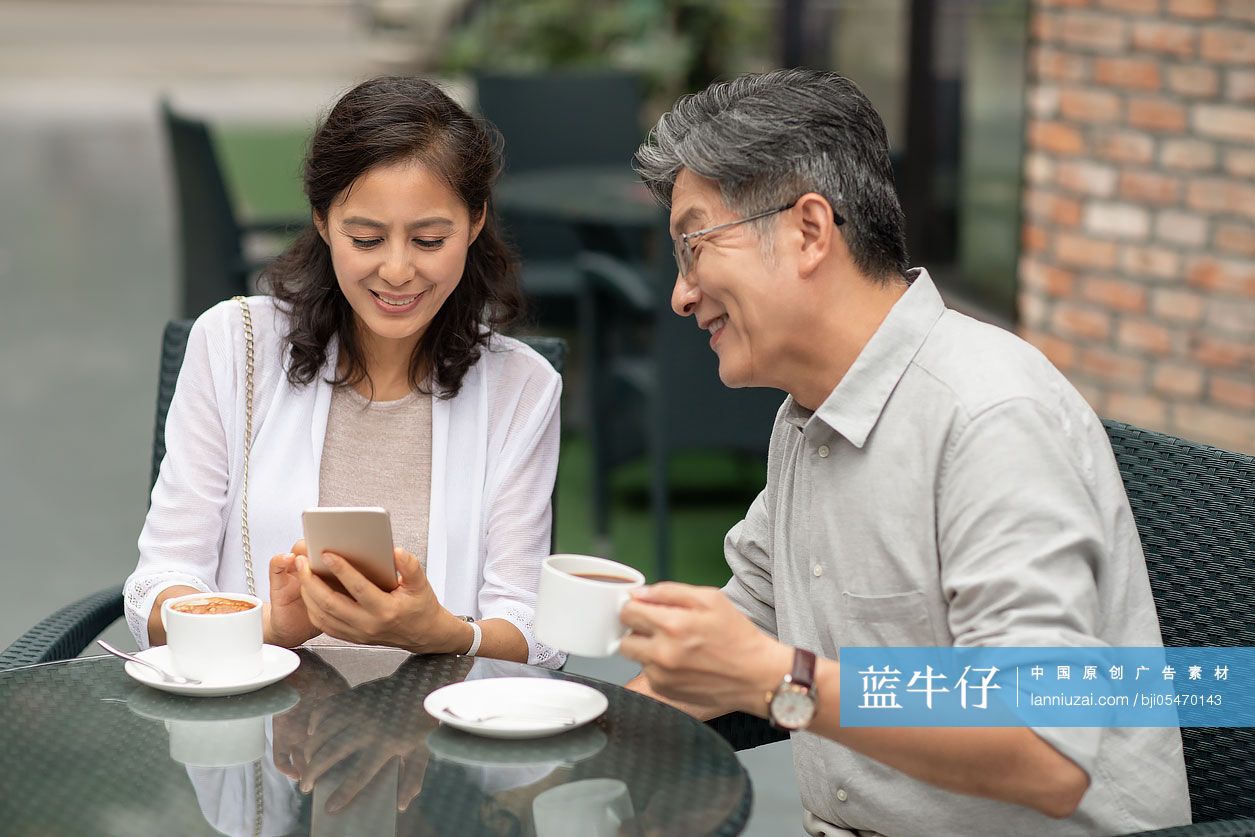 中老年夫妇在咖啡店使用手机