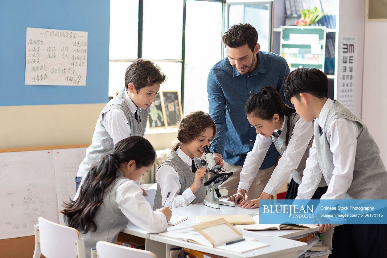 Students using microscope in classroom