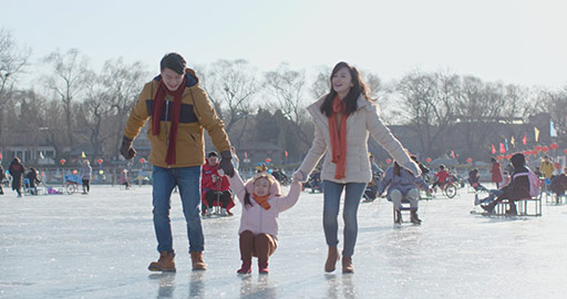 Happy young Chinese family having fun on ice,4K