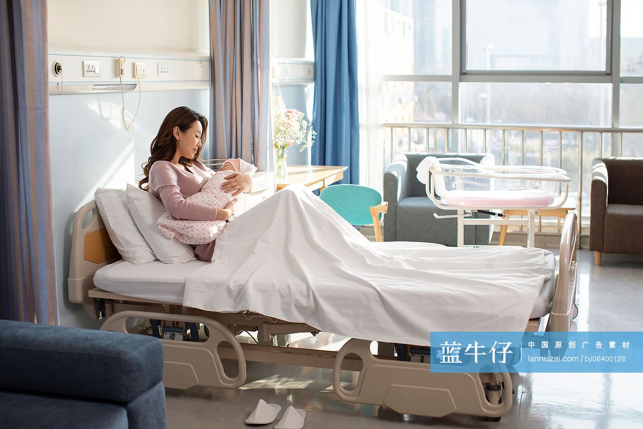 年轻的母亲在病房抱着刚出生的婴儿