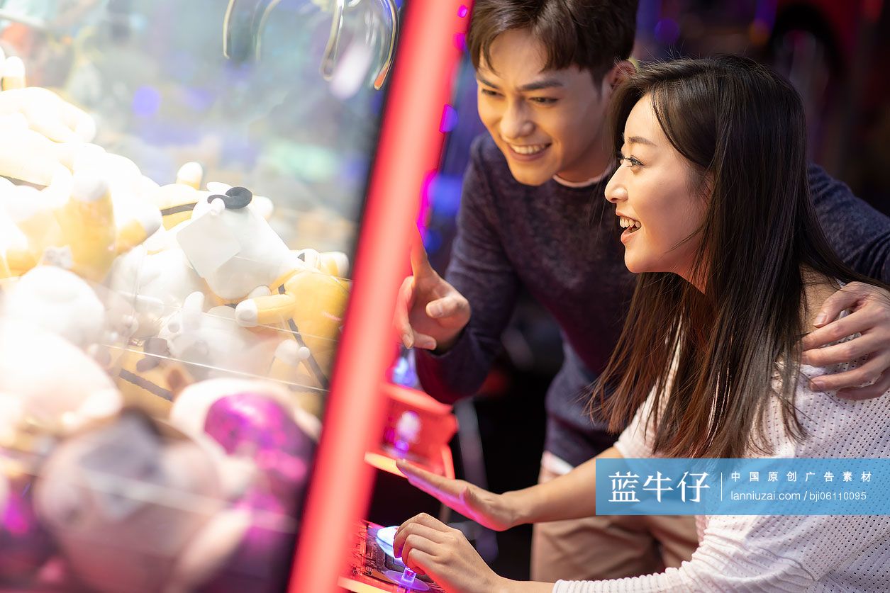 快乐的年轻情侣玩街机游戏