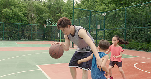 Young Chinese family playing basketball in park,4K