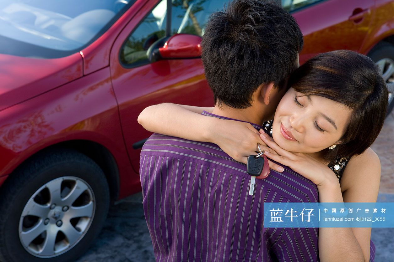 妻子手拿车钥匙在车前拥抱丈夫