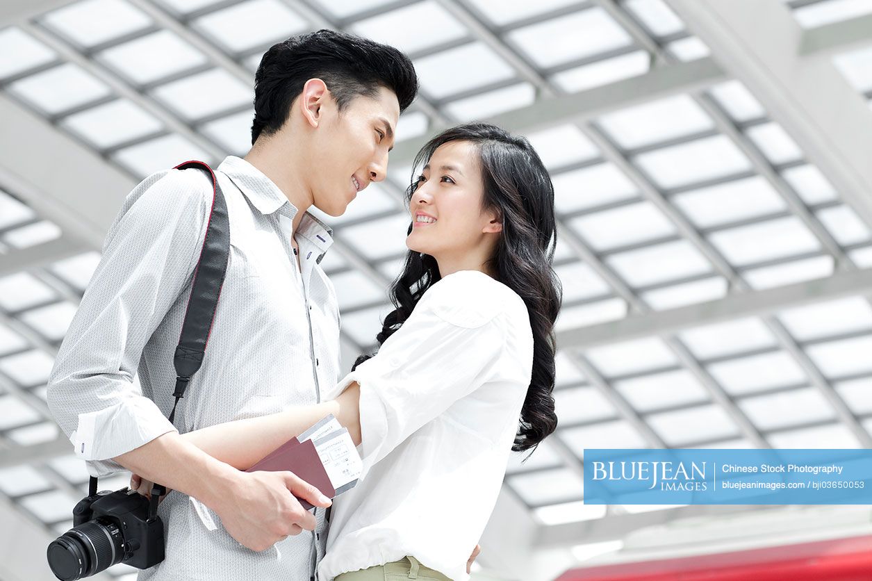 Chinese young couple embracing at subway station