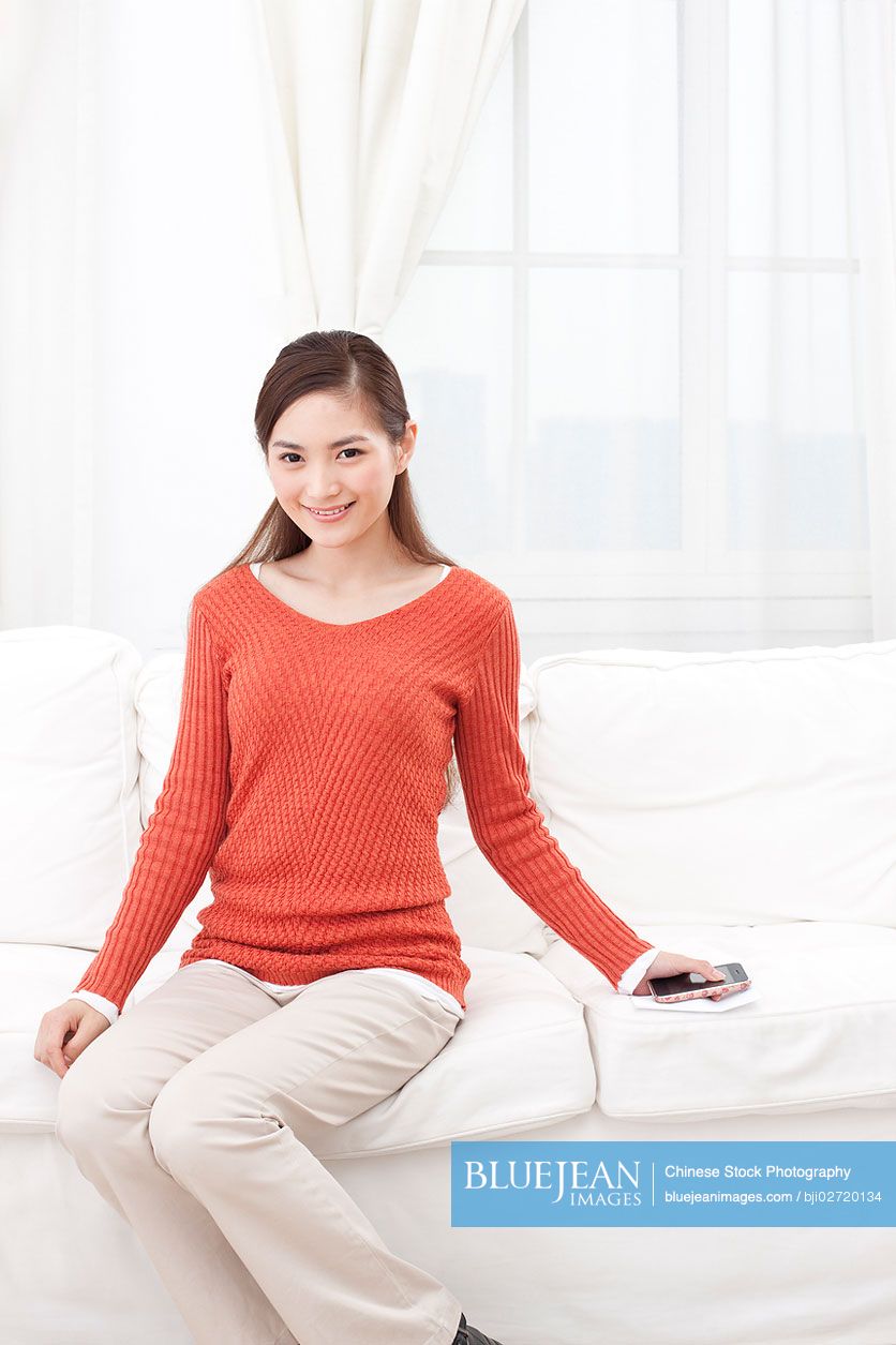 Young Chinese woman sitting in couch