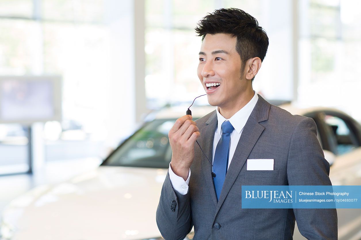 Confident Chinese car salesman with headset