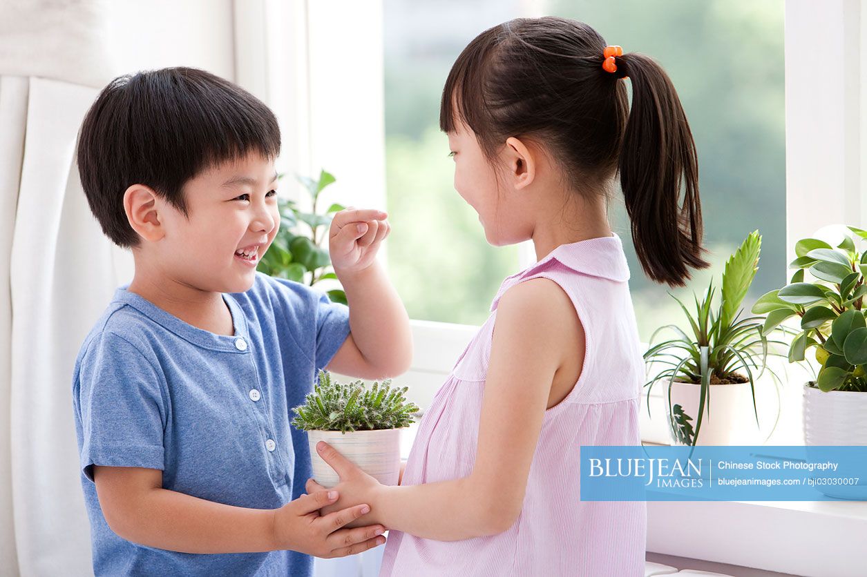 Chinese boy and girl holding the potted plants