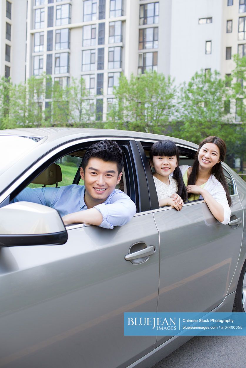 Happy young Chinese family in a car