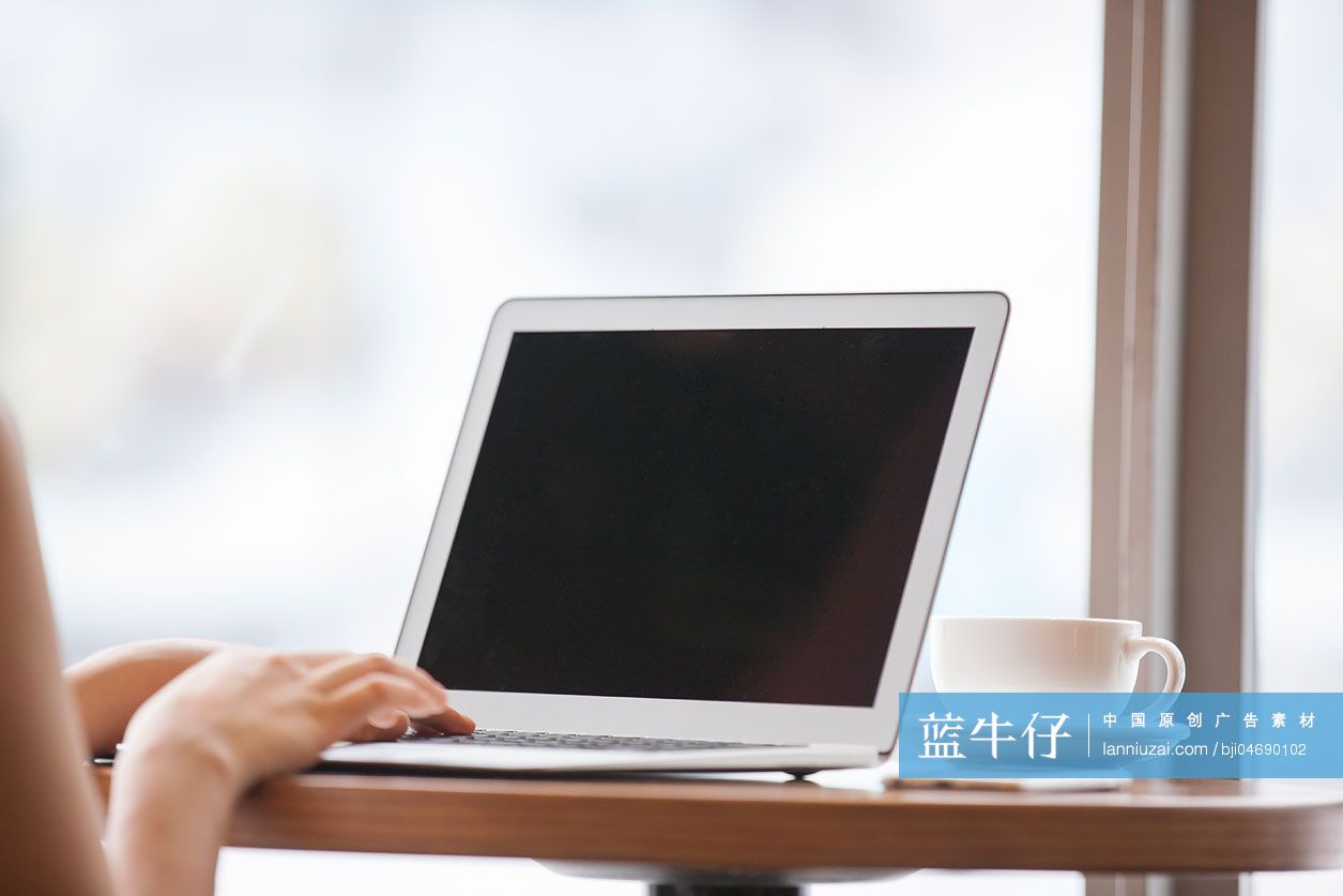 年轻女士在咖啡厅使用笔记本电脑工作