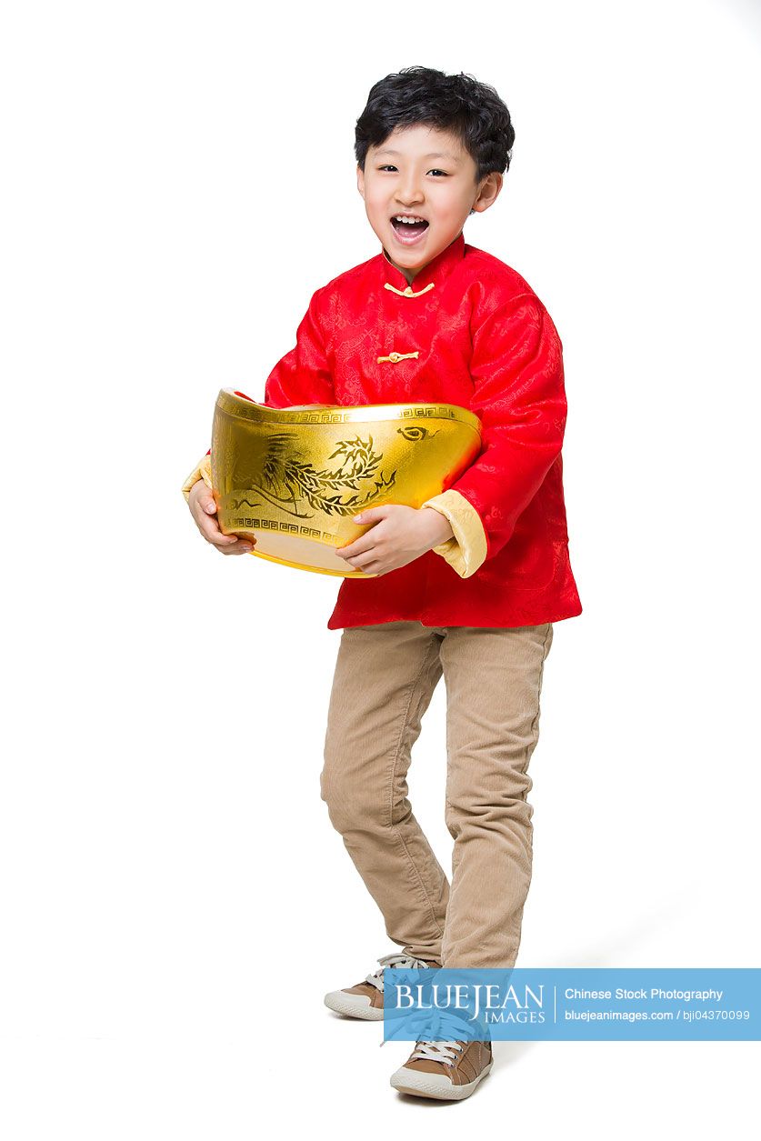 Happy boy holding a large Chinese traditional currency yuanbao