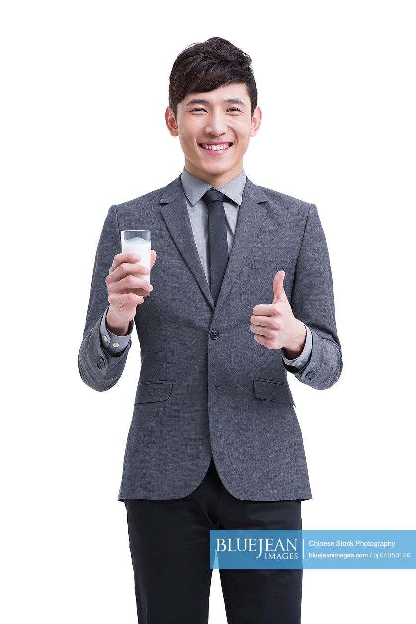Happy Chinese businessman with milk