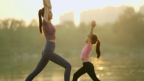 妈妈和女儿在公园练瑜伽