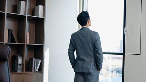 Successful Chinese businessman looking through window