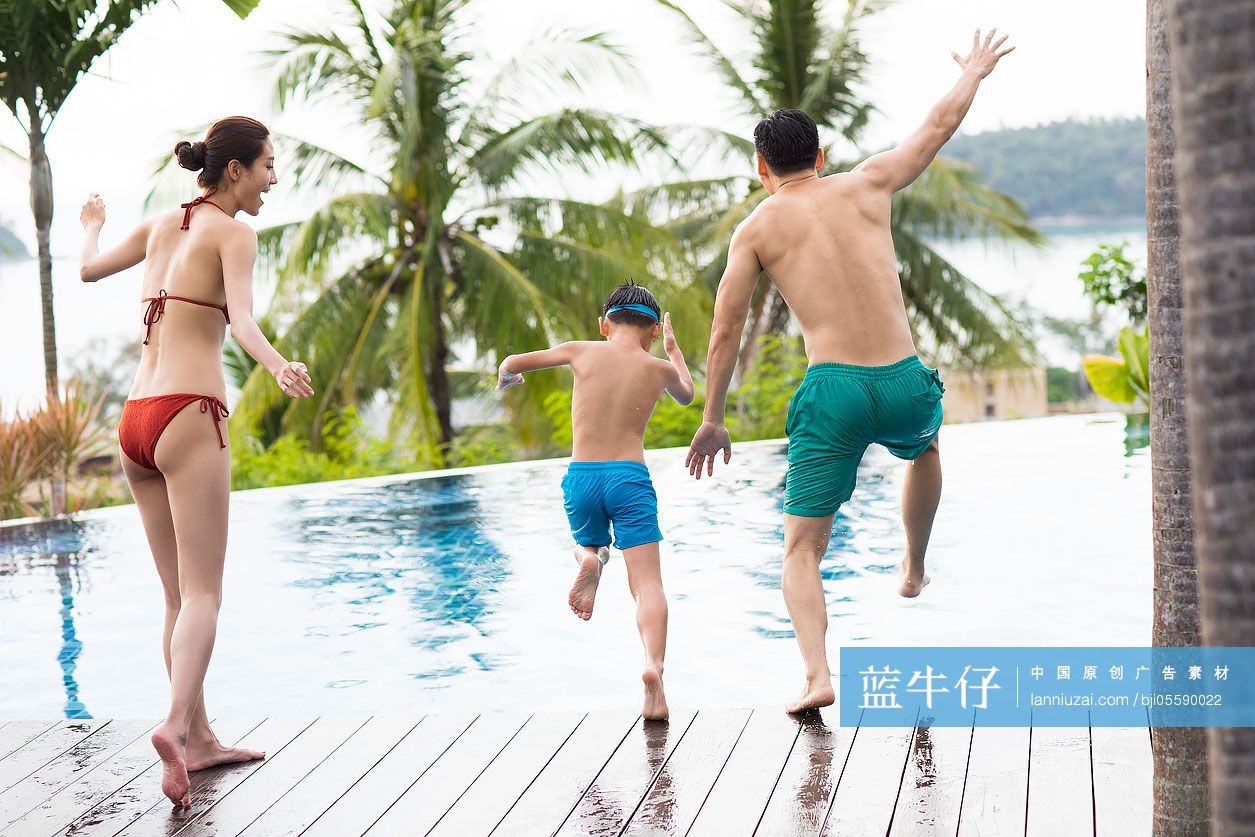 快乐的年轻家庭跳入泳池