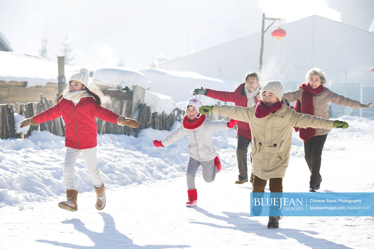 Happy Chinese family running in the snow