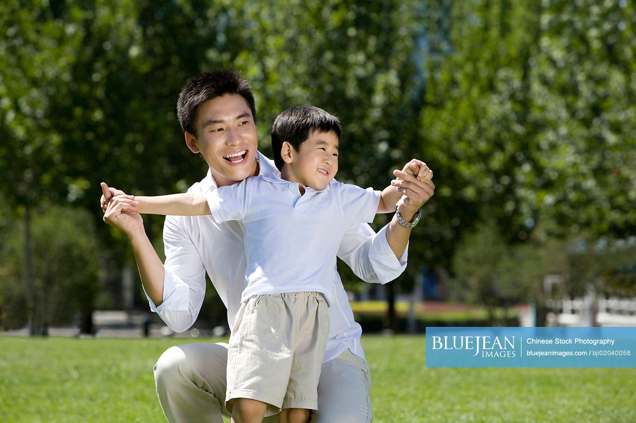 Chinese father and son playing in the park