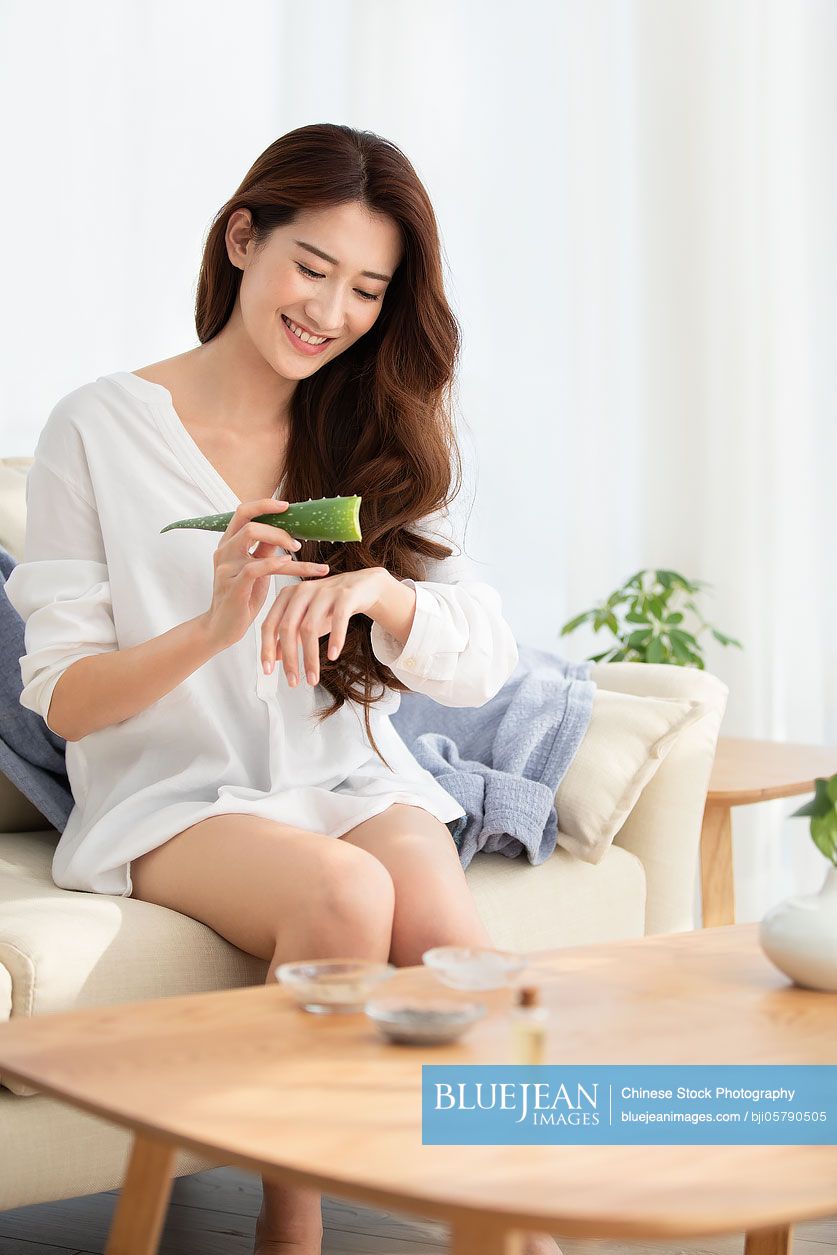 Young Chinese woman with natural aloe vera at home