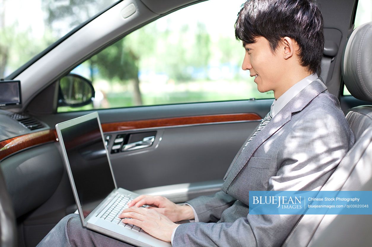 Chinese businessman surfing the net inside car
