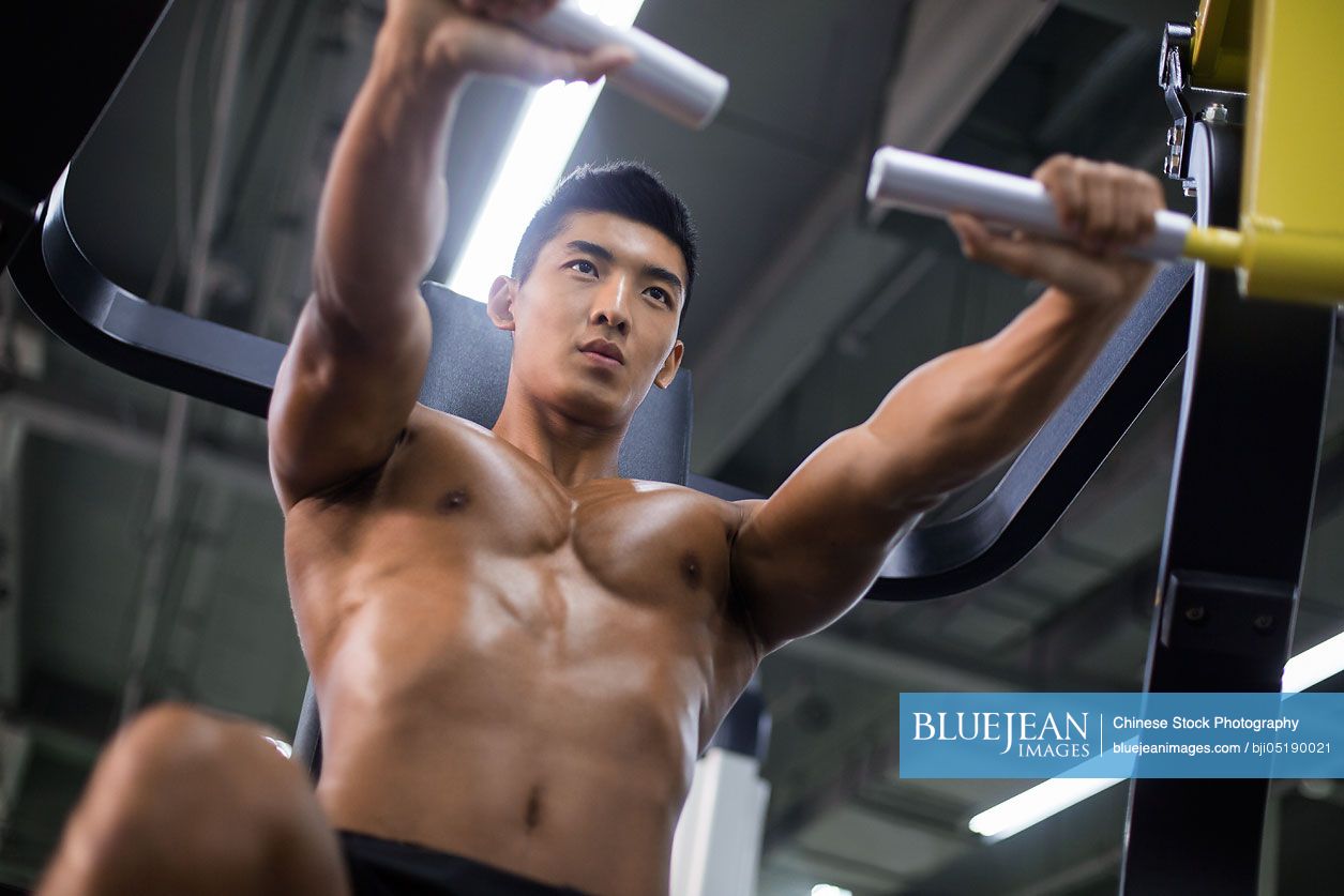 Young Chinese man exercising at gym