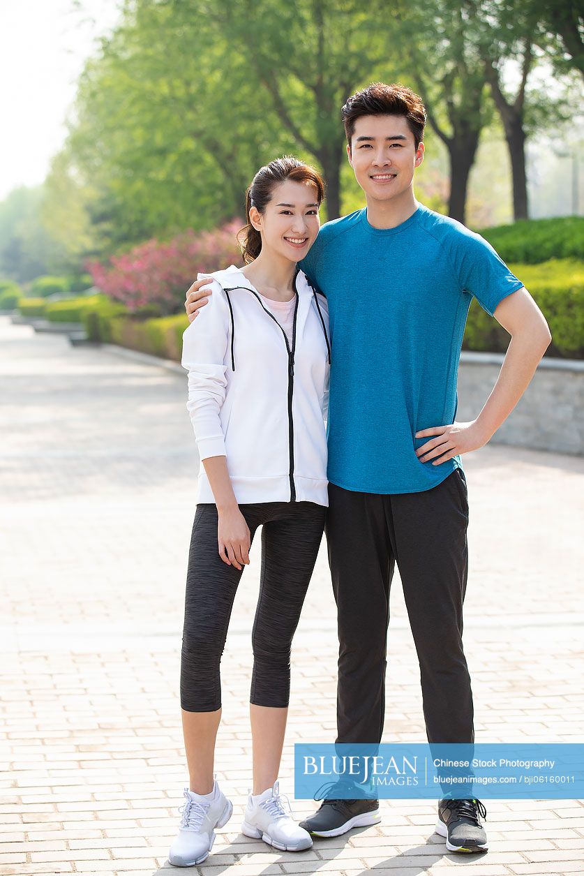 Happy young Chinese couple exercising in park
