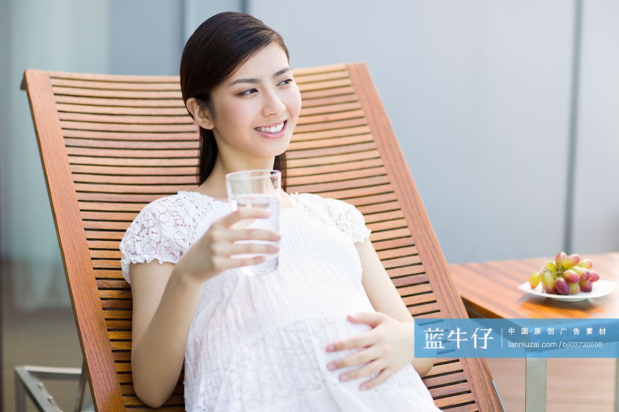 孕妇靠在躺椅上喝水