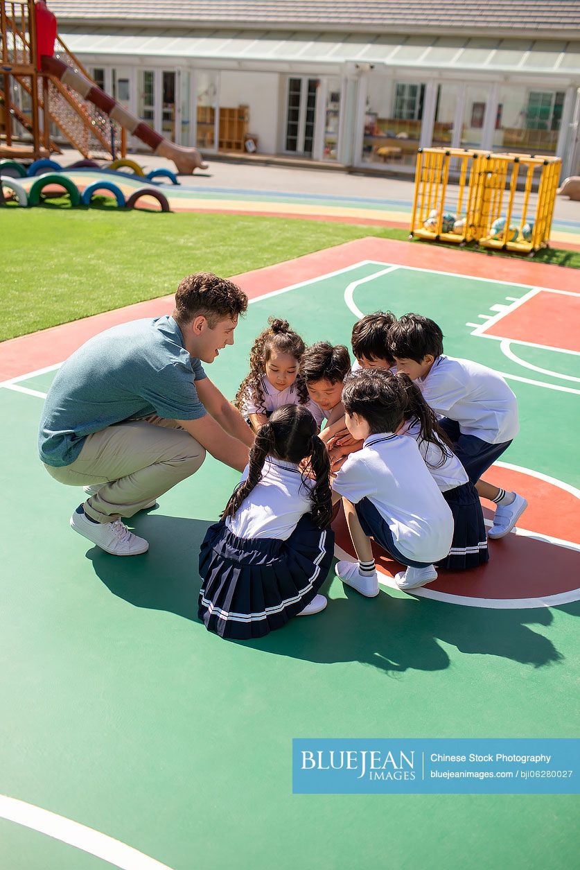 Foreign teacher and children playing in playground