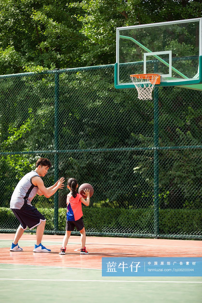 父女俩在运动场打篮球