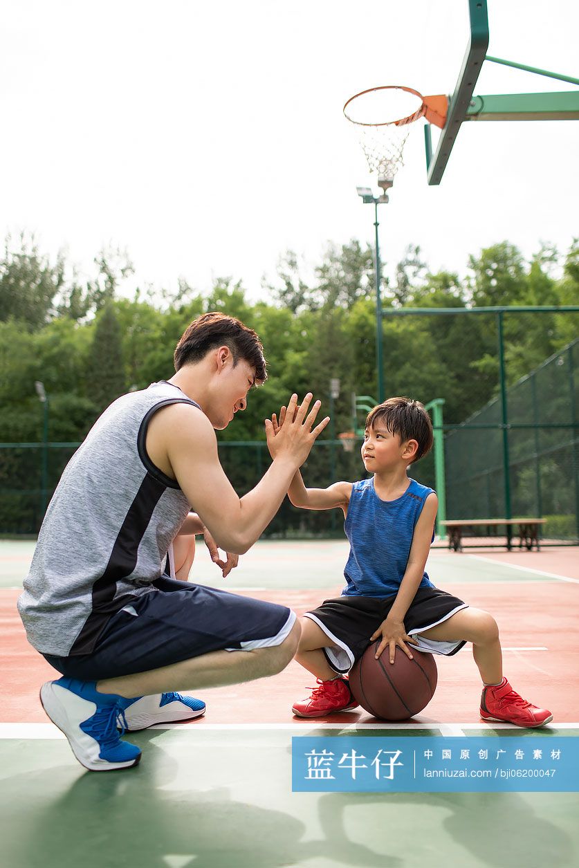 快乐的父子俩在运动场打篮球