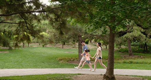 Happy young Chinese family walking in park,4K