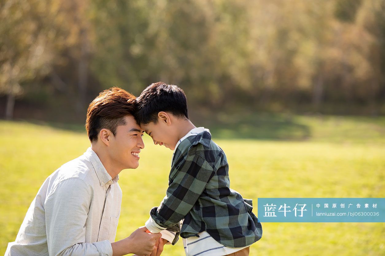 快乐的的父子俩在草地上玩耍