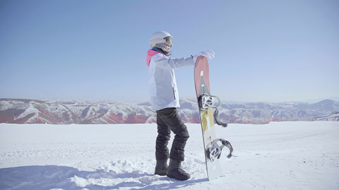 Young Chinese woman with snowboard on the snow,4K