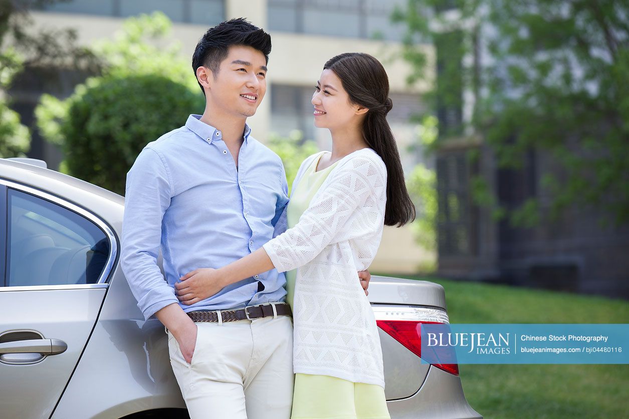 Happy young Chinese couple and car