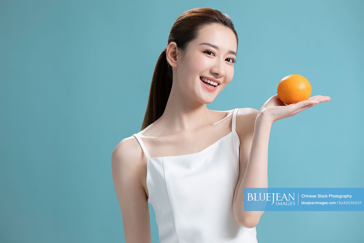 Beautiful young Chinese woman with oranges