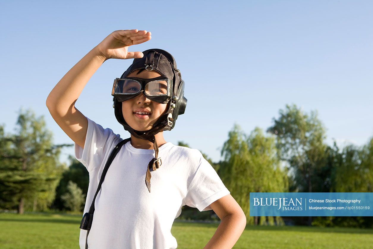 Young Chinese boy playing airplane pilot