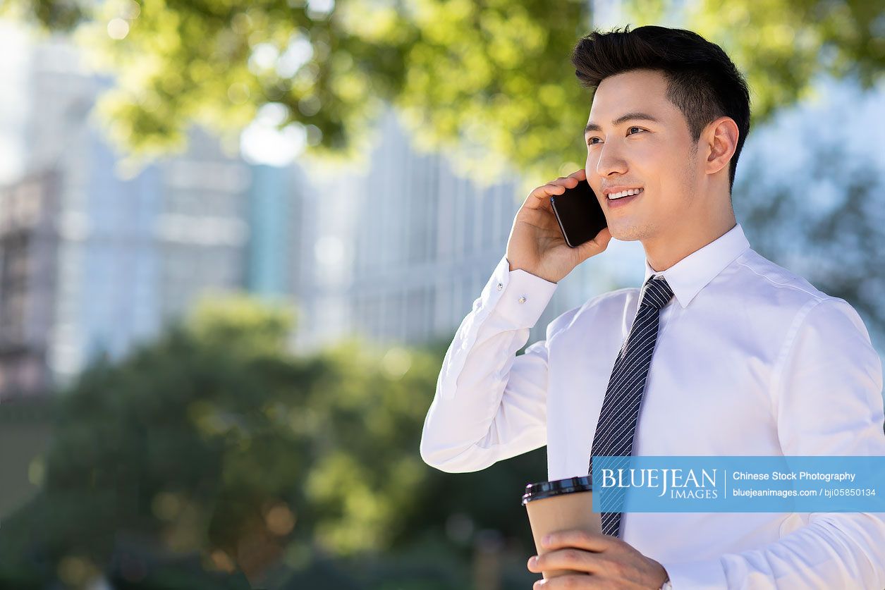 Confident young Chinese businessman on the phone
